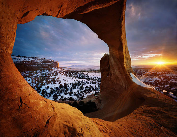 This image shows Wilson Arch near Moab, Utah. Snow is visible on the ground.