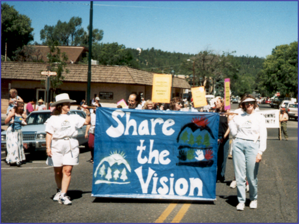 Two people carrying a sign reading "Share the Vision" at the 1997 Fourth of July parade in downtown Flagstaff